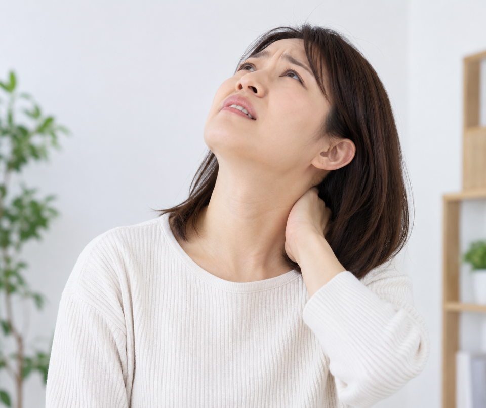 上を向いたり下を向いたりすると首の痛みを気にする50代女性